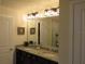 Bathroom featuring a double sink vanity with granite countertop and decorative light fixtures at 6147 Arbor Watch Loop, Orlando, FL 32829