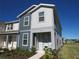 Charming two-story townhome with light gray and dark gray siding, neat landscaping and covered entry at 6147 Arbor Watch Loop, Orlando, FL 32829