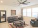 Comfortable living room with dark leather furniture, neutral walls, a ceiling fan, and large windows at 6147 Arbor Watch Loop, Orlando, FL 32829