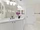Bright bathroom featuring double vanity, large mirror, and a glass-enclosed shower at 6881 Piazza St, Orlando, FL 32819