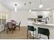 Modern kitchen featuring white cabinetry, pendant lighting, an eat-in bar, and an adjacent dining area at 6881 Piazza St, Orlando, FL 32819