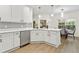 Well-lit kitchen featuring white cabinets, a stainless steel dishwasher, and an open view to the dining area at 6881 Piazza St, Orlando, FL 32819