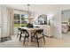 Bright dining room with modern chandelier, decorative mirror, and a view to the outdoors at 8718 Sw 139Th Place Rd # 29, Ocala, FL 34473