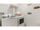 Functional laundry room with modern washer, dryer, overhead shelving, and decorative wall signs at 8718 Sw 139Th Place Rd # 29, Ocala, FL 34473