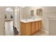 Bathroom features a double sink with wood-look cabinets, and an open view to the living area with wood floors at 9526 Water Fern Cir, Clermont, FL 34711