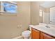 Bathroom with toilet and sink, accompanied by a window allowing natural light at 9526 Water Fern Cir, Clermont, FL 34711
