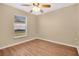 This bedroom with wood flooring provides both comfort and style, enhanced by a ceiling fan at 9526 Water Fern Cir, Clermont, FL 34711