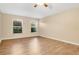 Neutral bedroom with wood-look flooring and two windows at 9526 Water Fern Cir, Clermont, FL 34711