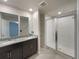 Bathroom featuring dual sinks, granite counters, and a glass enclosed shower at 987 Desert Candle Dr, Ocoee, FL 34761