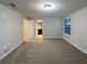 Spacious bedroom featuring neutral walls, carpeted floors, a window with blinds, and a doorway to bathroom at 987 Desert Candle Dr, Ocoee, FL 34761