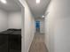 Hallway view showcasing the laundry room, neutral walls, carpeted floor, and white doors at 987 Desert Candle Dr, Ocoee, FL 34761