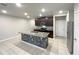 Modern kitchen features an island with stone accents, granite countertops, and stainless steel appliances at 987 Desert Candle Dr, Ocoee, FL 34761