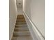 Carpeted staircase leads to the upper level of the home with white rails at 987 Desert Candle Dr, Ocoee, FL 34761