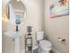 Charming powder room featuring pedestal sink, modern fixtures, and beach-themed decor at 10732 Petrillo Way, Winter Garden, FL 34787