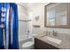 Nicely designed bathroom with granite countertops, shower and tub, baseball-themed curtain and decor at 10732 Petrillo Way, Winter Garden, FL 34787