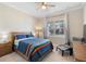 Bright bedroom showcasing a ceiling fan, comfortable bed, and a large window for ample natural light at 10732 Petrillo Way, Winter Garden, FL 34787