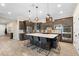 Modern kitchen with dark cabinets, large island with seating, pendant lighting, and stainless steel appliances at 10732 Petrillo Way, Winter Garden, FL 34787