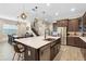 Modern kitchen with stainless steel appliances, dark cabinets, and center island with sink and light stone countertop at 10732 Petrillo Way, Winter Garden, FL 34787