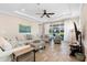 Living room with tile floors, tray ceilings, fan, and sliding glass doors at 10732 Petrillo Way, Winter Garden, FL 34787