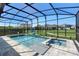 Screened in pool with a hot tub, stone decking, and a lush green backyard at 10732 Petrillo Way, Winter Garden, FL 34787