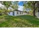 Exterior view of the home and backyard, featuring manicured lawn and mature trees at 1104 Grove Manor Dr, Sanford, FL 32771