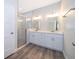 Bathroom features double sink vanity with white cabinets, modern fixtures, and glass shower at 1104 Grove Manor Dr, Sanford, FL 32771