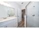 Modern bathroom featuring a glass enclosed shower, white cabinets and a large mirror at 1104 Grove Manor Dr, Sanford, FL 32771