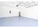Spacious garage with painted floor, water heater, white door, and a modern garage door at 1104 Grove Manor Dr, Sanford, FL 32771