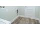 Laundry area features wood floors, base trim, and access to the exterior of the home at 1104 Grove Manor Dr, Sanford, FL 32771