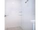 Modern shower featuring white tiled walls, glass shelving, and a stone tiled floor at 1104 Grove Manor Dr, Sanford, FL 32771
