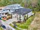 Aerial view of a two-story home with a paver driveway, lush landscaping and three car garage at 1281 Grand Traverse Pkwy, Reunion, FL 34747
