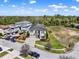 An aerial view of the home featuring a paved driveway and manicured lawns near a vacant lot at 1281 Grand Traverse Pkwy, Reunion, FL 34747
