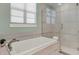 Well-lit bathroom featuring a soaking tub and glass-enclosed shower at 1281 Grand Traverse Pkwy, Reunion, FL 34747