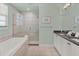 Well-lit bathroom with a large soaking tub and glass-enclosed shower at 1281 Grand Traverse Pkwy, Reunion, FL 34747