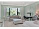 This spacious bedroom features a sitting area with a couch, ottoman, desk, and large windows at 1281 Grand Traverse Pkwy, Reunion, FL 34747