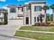 A stunning two-story stucco home boasts a brick accent wall, well-manicured lawn, and a paved driveway at 1281 Grand Traverse Pkwy, Reunion, FL 34747