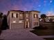 Charming two-story home featuring stone accents, a paver driveway, and exterior lighting at 1281 Grand Traverse Pkwy, Reunion, FL 34747