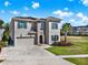 Stunning two-story home boasting stone accents, a paver driveway, and lush landscaping at 1281 Grand Traverse Pkwy, Reunion, FL 34747