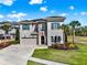 Beautiful two-story home featuring stone accents, a paver driveway, and mature landscaping at 1281 Grand Traverse Pkwy, Reunion, FL 34747