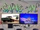 A graffiti-themed game room featuring dual wall-mounted TVs and comfortable chairs at 1281 Grand Traverse Pkwy, Reunion, FL 34747