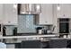 Modern kitchen featuring white cabinets, a subway tile backsplash and stainless steel appliances at 1281 Grand Traverse Pkwy, Reunion, FL 34747