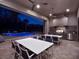 Covered outdoor kitchen and dining area overlooking a pool and spa at night, great for entertaining at 1281 Grand Traverse Pkwy, Reunion, FL 34747
