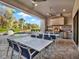 A spacious outdoor kitchen and dining area, complete with a built-in grill and a view of the private pool at 1281 Grand Traverse Pkwy, Reunion, FL 34747