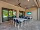 This covered patio includes an outdoor dining setup and ceiling fans for a relaxing entertainment area at 1281 Grand Traverse Pkwy, Reunion, FL 34747