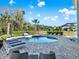 This backyard features a luxurious pool and spa, surrounded by lush landscaping and comfortable lounge chairs at 1281 Grand Traverse Pkwy, Reunion, FL 34747
