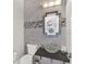 Stylish powder room with gray tile, vanity with glass bowl sink, and an ornate mirror at 1281 Grand Traverse Pkwy, Reunion, FL 34747