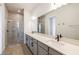 Modern bathroom featuring double sinks, quartz countertops, and a glass-enclosed shower at 13676 Mcmillan Dr, Orlando, FL 32827