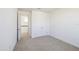Well-lit bedroom with a neutral carpet, double door closet, and doorway leading to the hall at 13676 Mcmillan Dr, Orlando, FL 32827