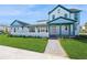 Inviting two-story home with a manicured lawn, turquoise accents, and a charming porch at 13676 Mcmillan Dr, Orlando, FL 32827