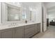 Well-lit bathroom featuring double sinks, stylish gray cabinets, and modern fixtures at 13759 Mommsen Ave, Orlando, FL 32827